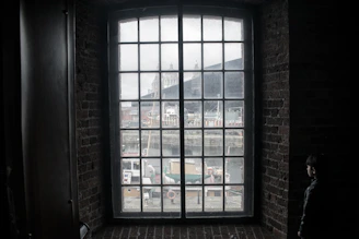 Loft apartments with large windows overlooking a bustling harbor at dawn.