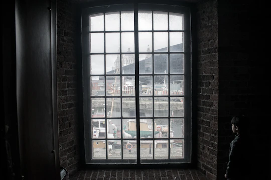 Loft apartments with large windows overlooking a bustling harbor at dawn.