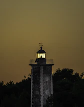 A sleek minimalist lighthouse glowing softly against a twilight sky.