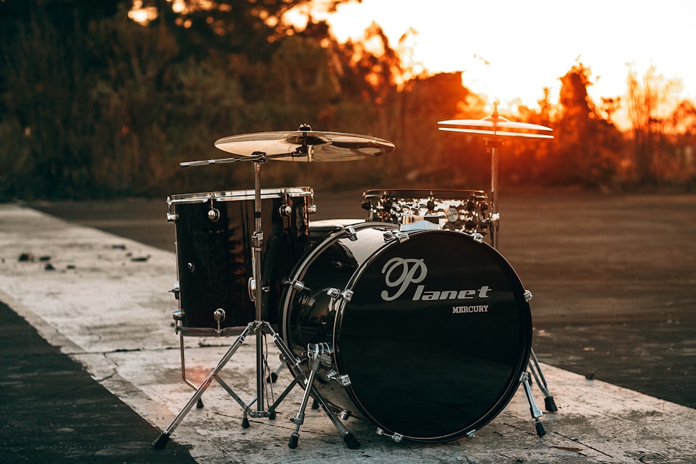 black Planet drum kit near trees during sunset