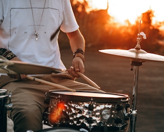 person playing drum during golden hour