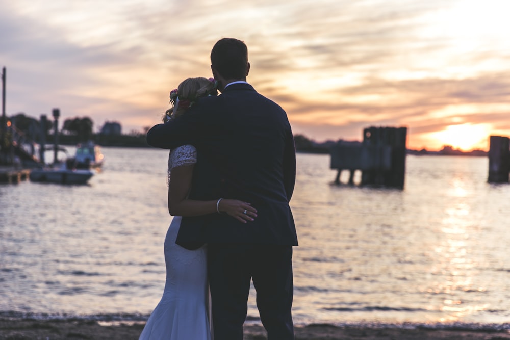 bride and groom hugging near seashore