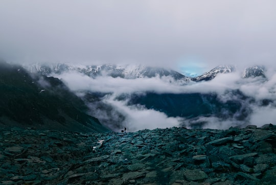 person standing on top of mountain surrounded by sea of clouds in Siguniang Mountain China