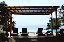 photo of four loungers under gazebo facing swimming pool