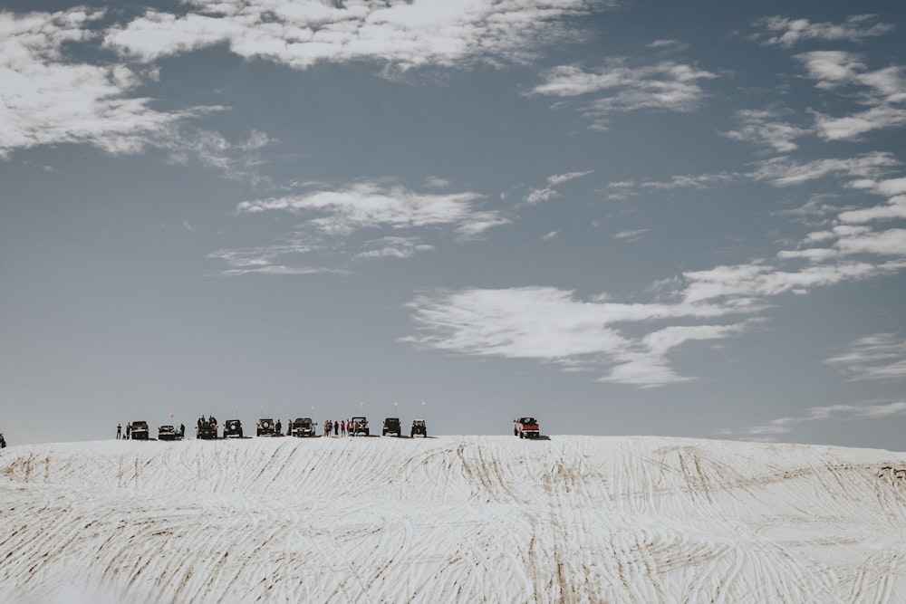 cars on top on white sand hill during daytime