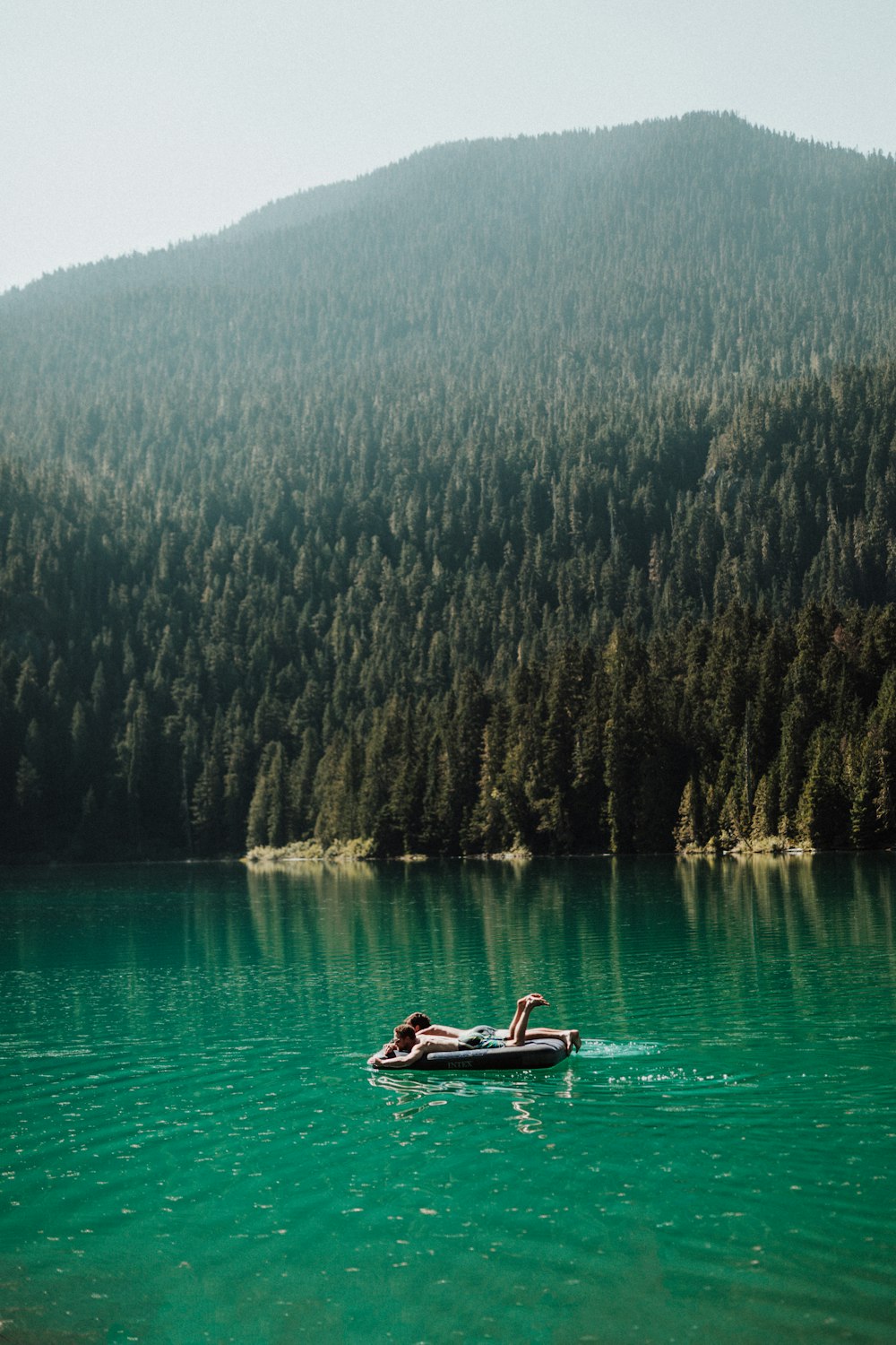 hombres acostados en flotador en el lago