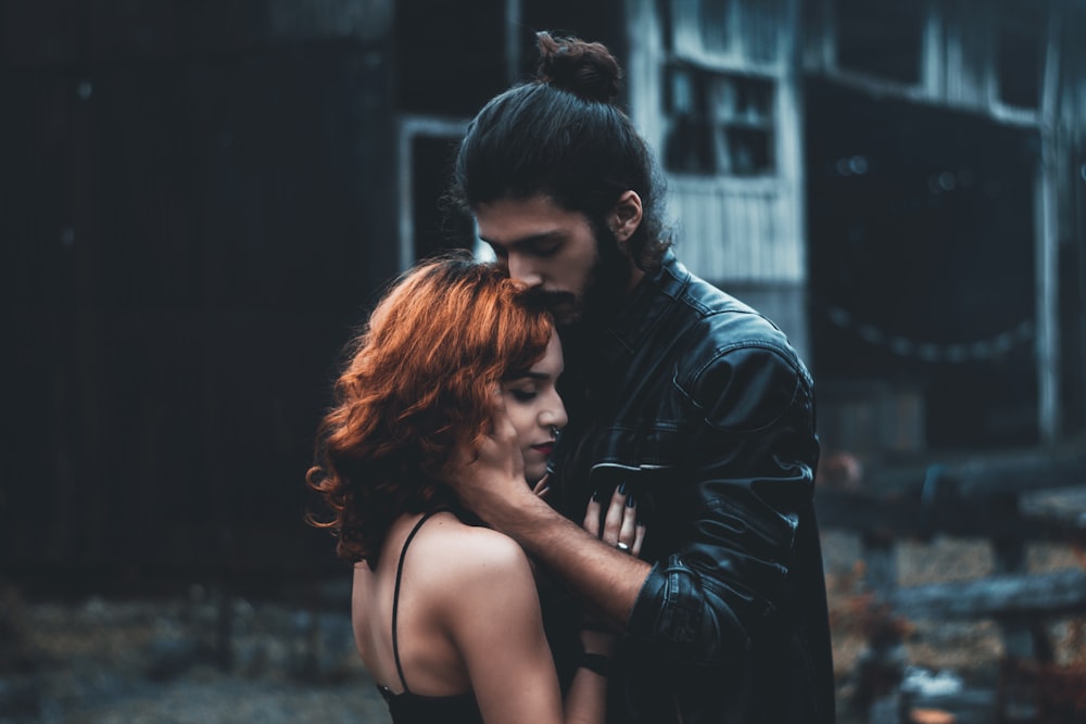 shallow focus photography of man and woman hugging