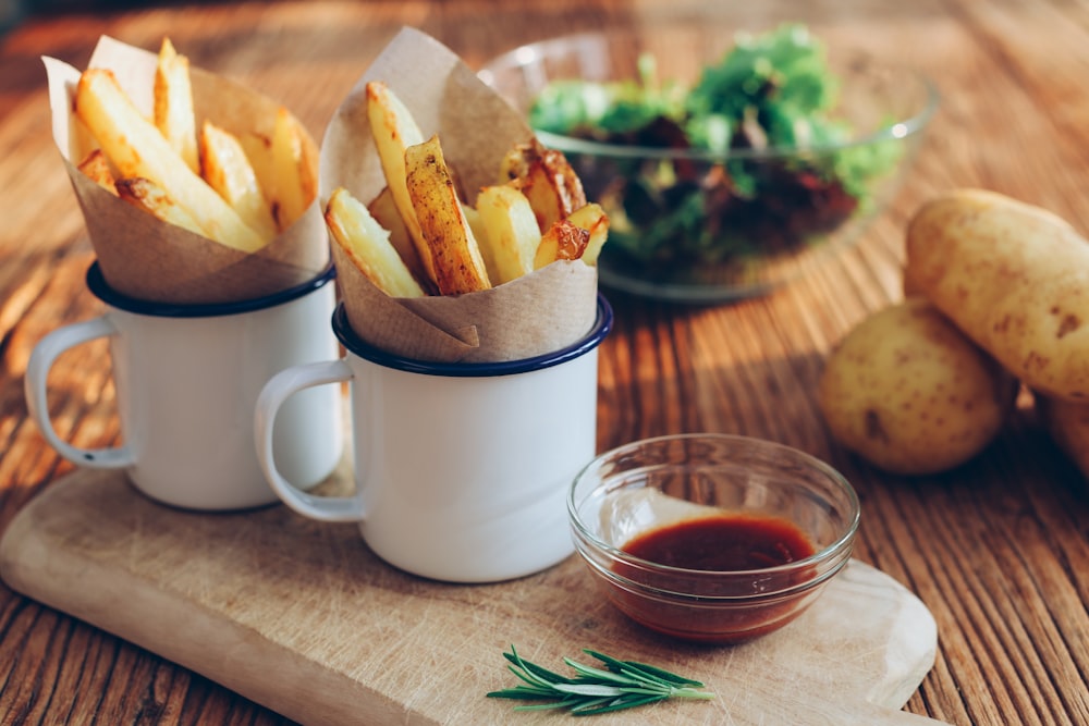 potato fries on mugs beside sauce