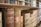 Rows of old, leather-bound books with embossed titles sit on a wooden bookshelf. The spines show signs of aging and wear, hinting at the historical significance and the vintage quality of the collection.