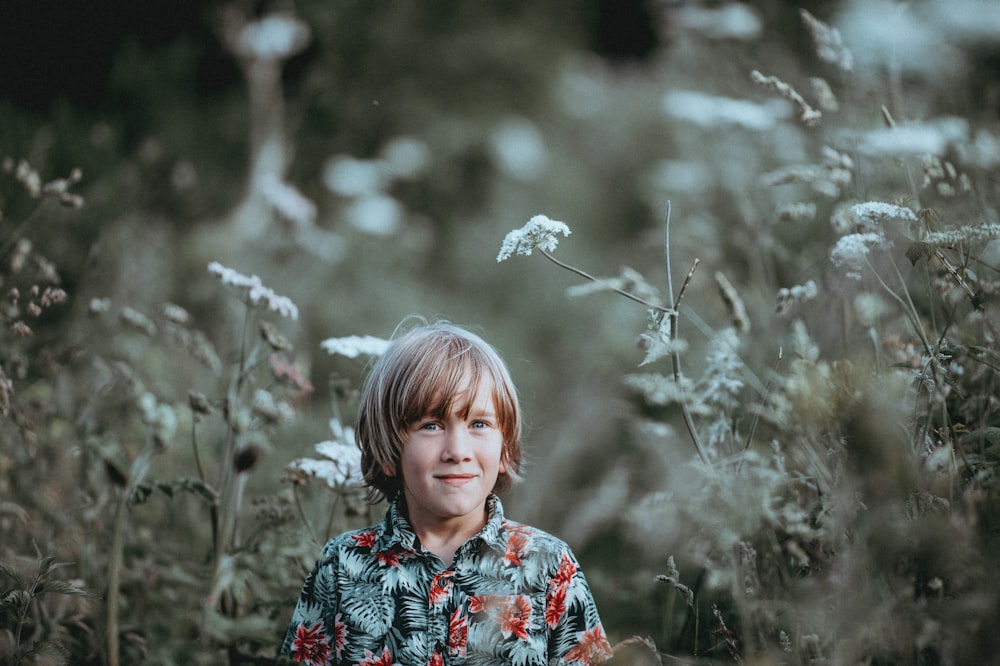 Niño de pie sobre plantas de hojas verdes