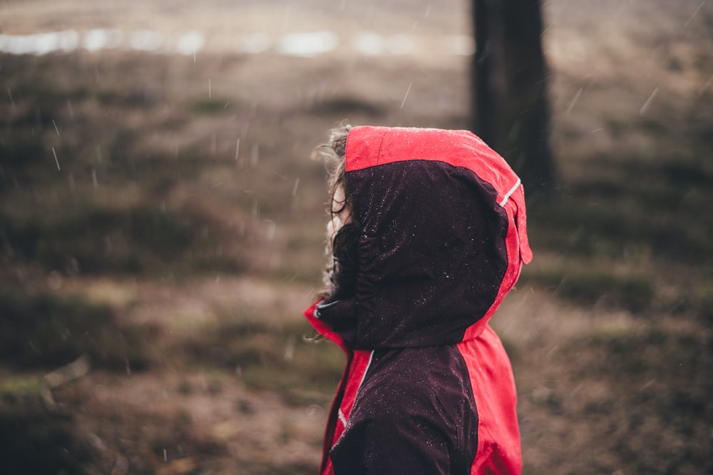 person in red and black hooded jacket