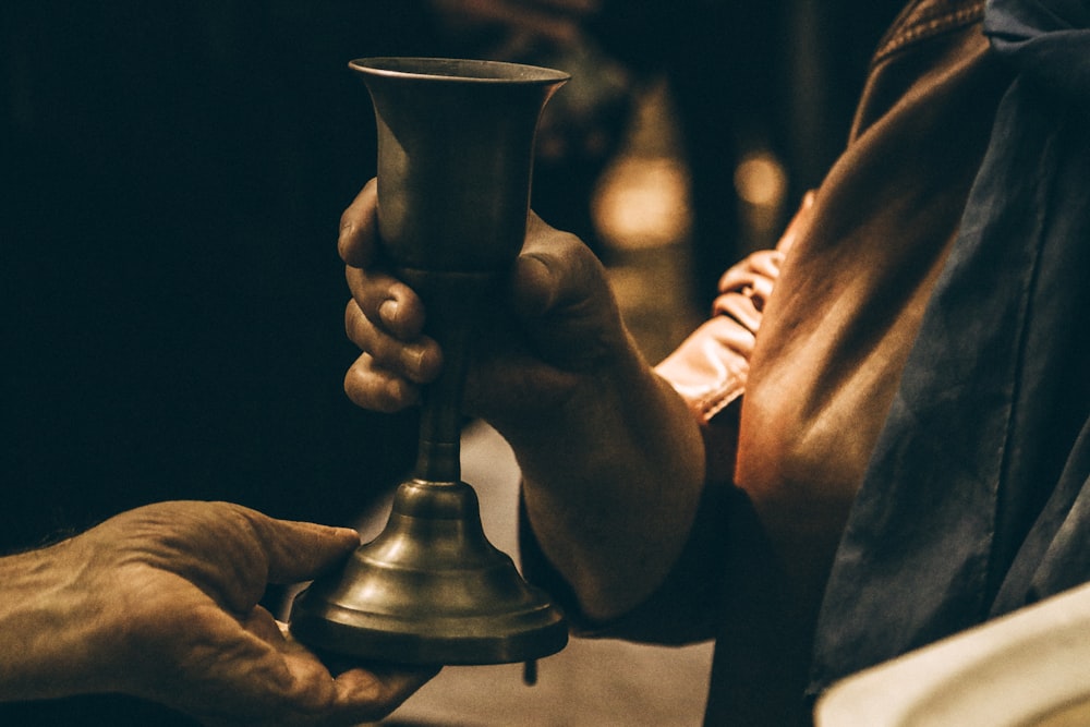 person holding gold chalice