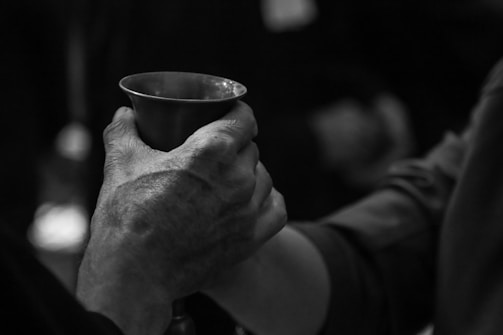 Close-up of hands holding a copper coffee cup beside gym equipment.