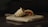 A wrap or burrito filled with meat and vegetables rests on a wooden cutting board on a dark surface. The filling includes pieces of meat and chopped vegetables, visible at the cut end of the wrap.