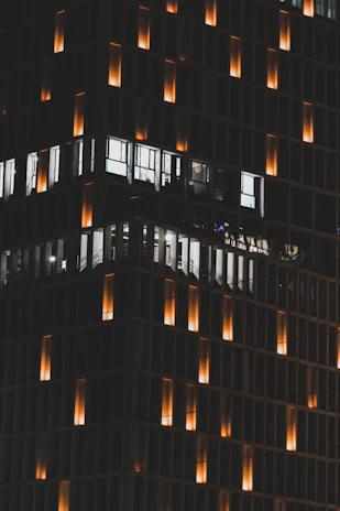 A sleek office building illuminated by warm orange lighting at dusk, symbolizing a guiding beacon.