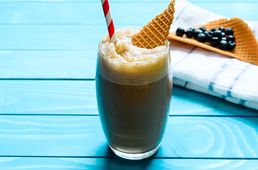 a glass of milkshake with an ice cream cone on top