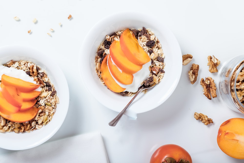 bowl of cereal with sliced fruits and spoon