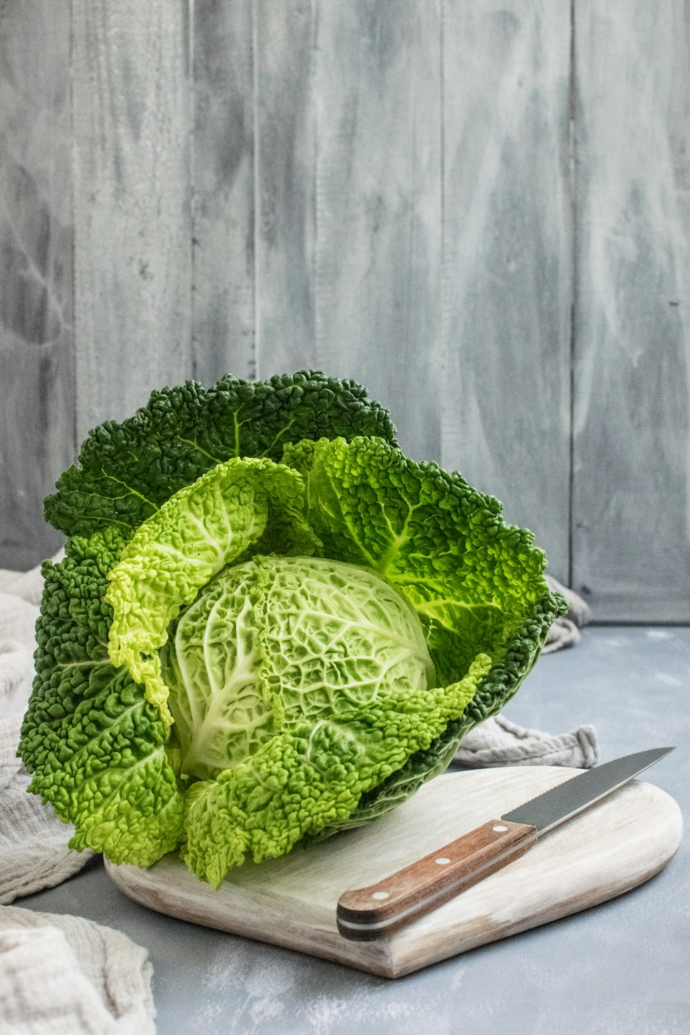 green cabbage on brown wooden chopping board