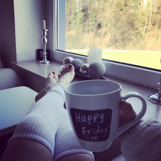 A cozy indoor scene with a person relaxing in a phonix sun hoodie, a warm cup of tea nearby.