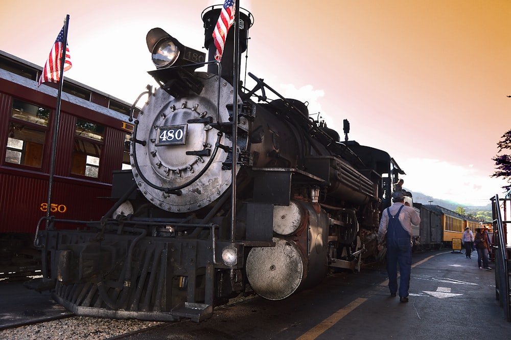 man walking beside locomotive train