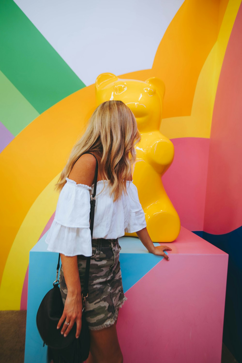 woman watching yellow bear sculpture