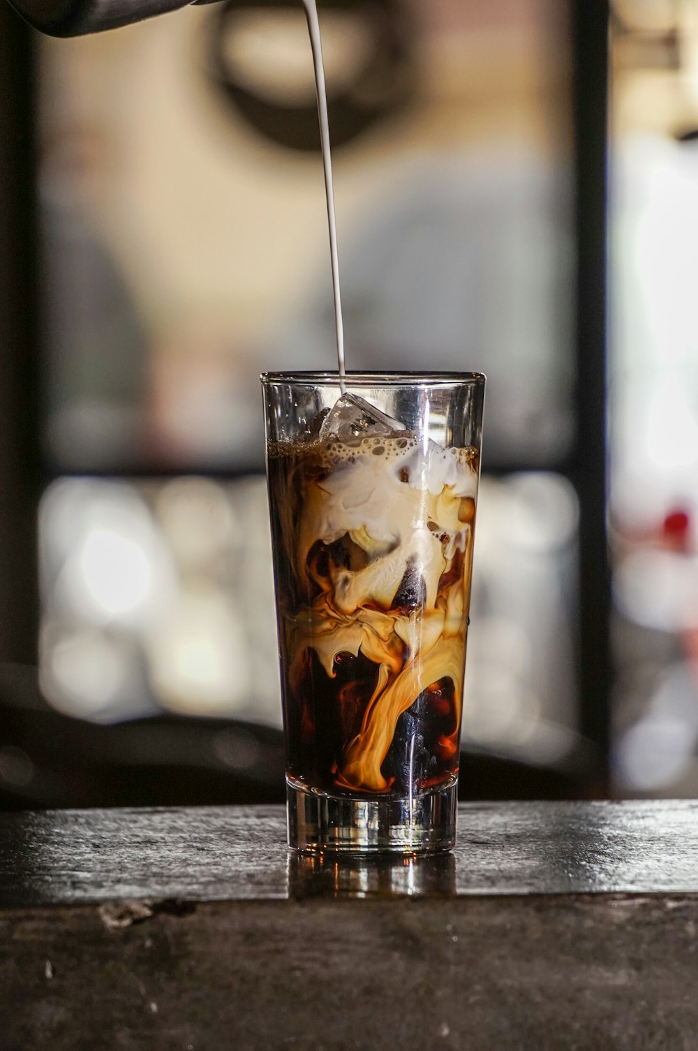 selective focus photography of milk pouring on shot glass