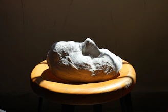 Finished mask displayed on a dark velvet stand, highlighting its imperfections.
