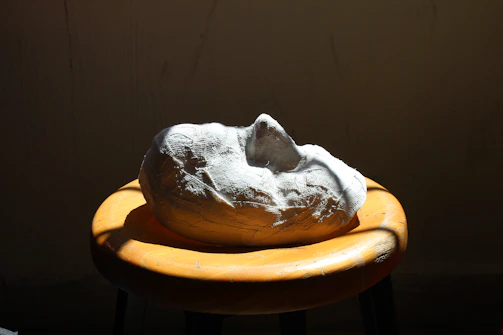 Finished mask displayed on a dark velvet stand, highlighting its imperfections.