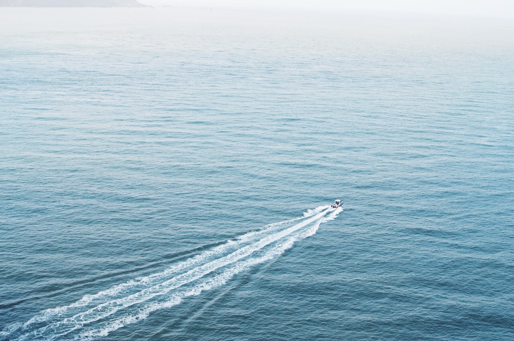 Photographie aérienne d’un bateau à moteur au milieu de l’océan