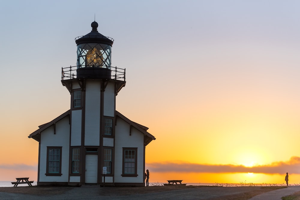 Vue sur la tour du phare blanc et brun au coucher du soleil