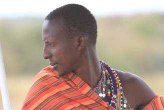 Close-up of a young woman wearing vibrant turquoise and fuchsia jewelry against a Baja California sunset.