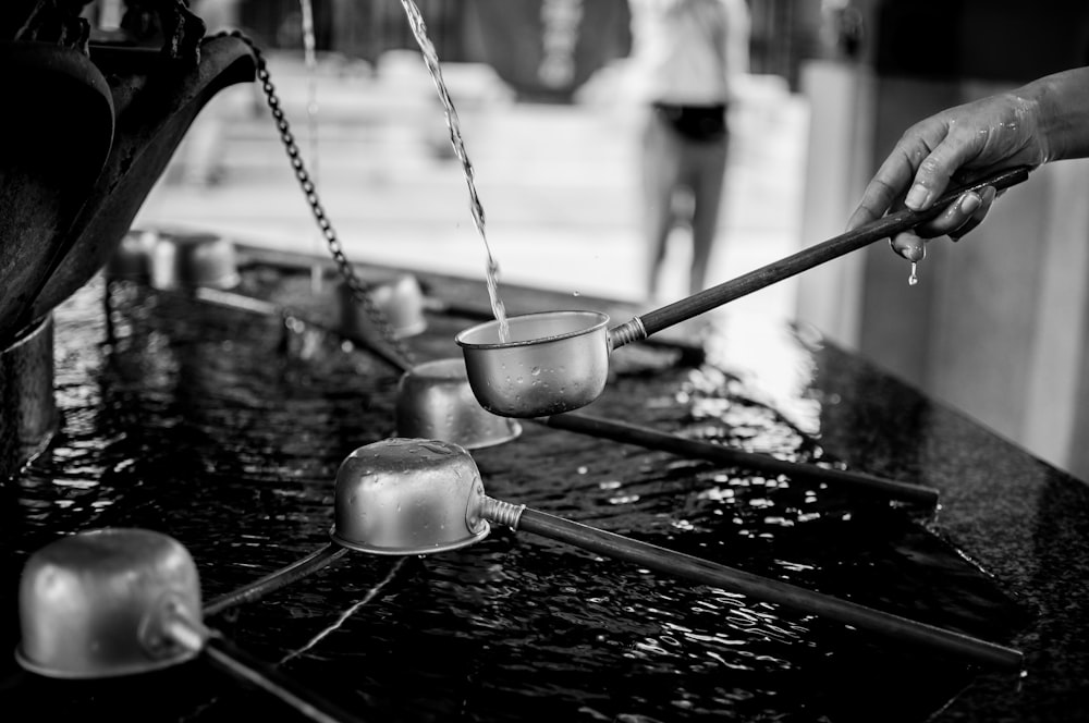 grayscale photography of a person holding ladle