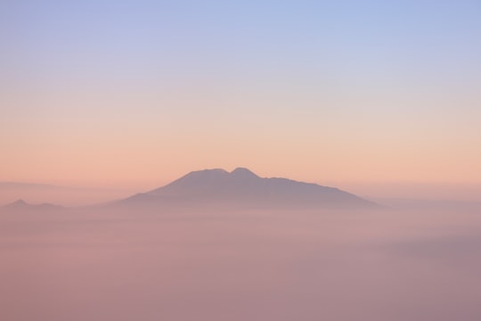 black mountain under blue sky at daytime in Malang Indonesia