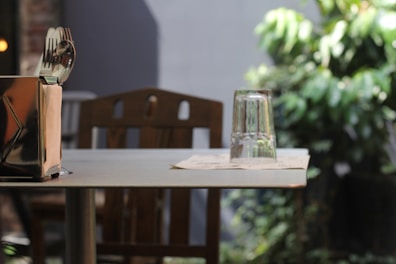 A set of biodegradable cutlery neatly arranged on a rustic wooden table outdoors.