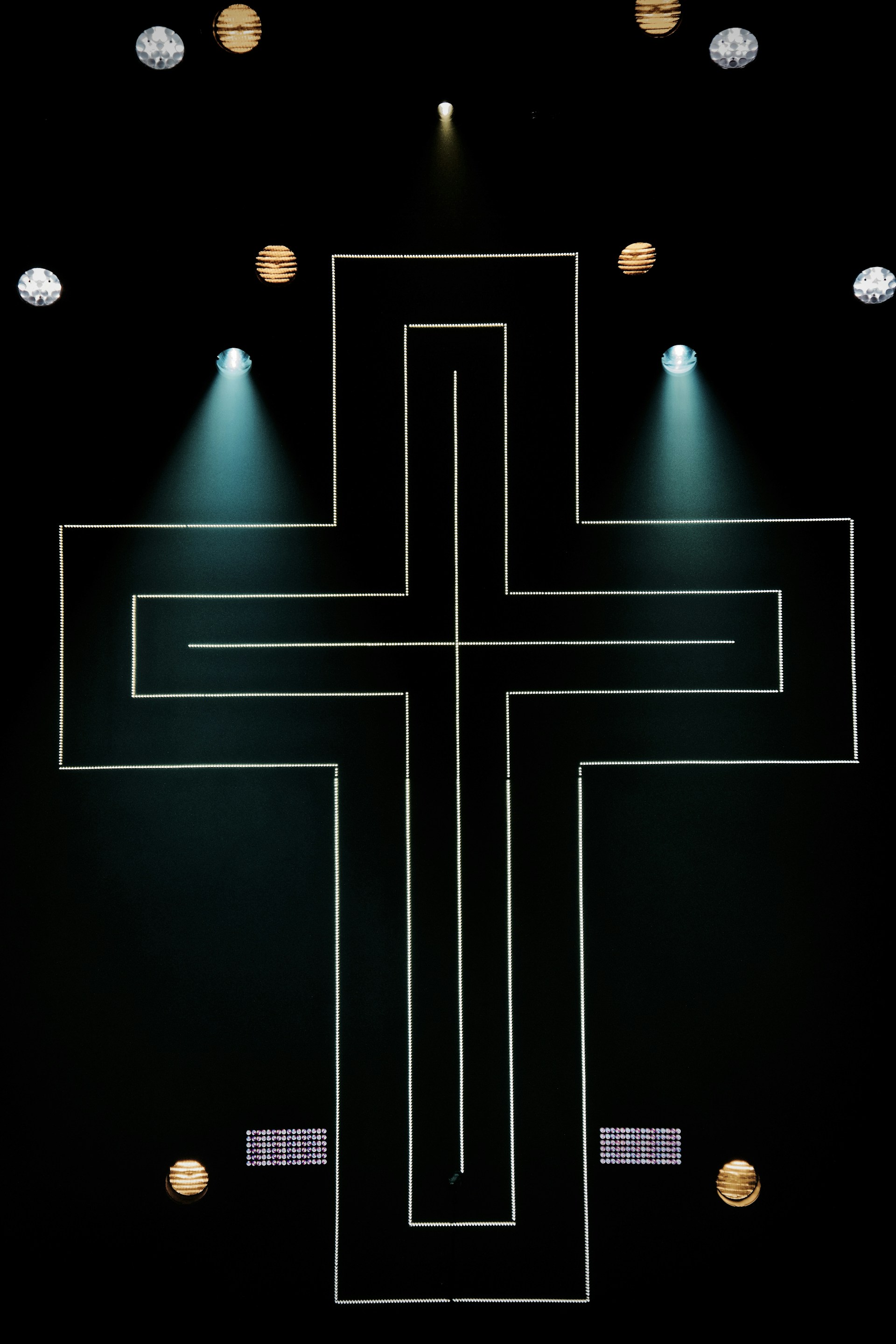 string lights cross on dark area with spot lights