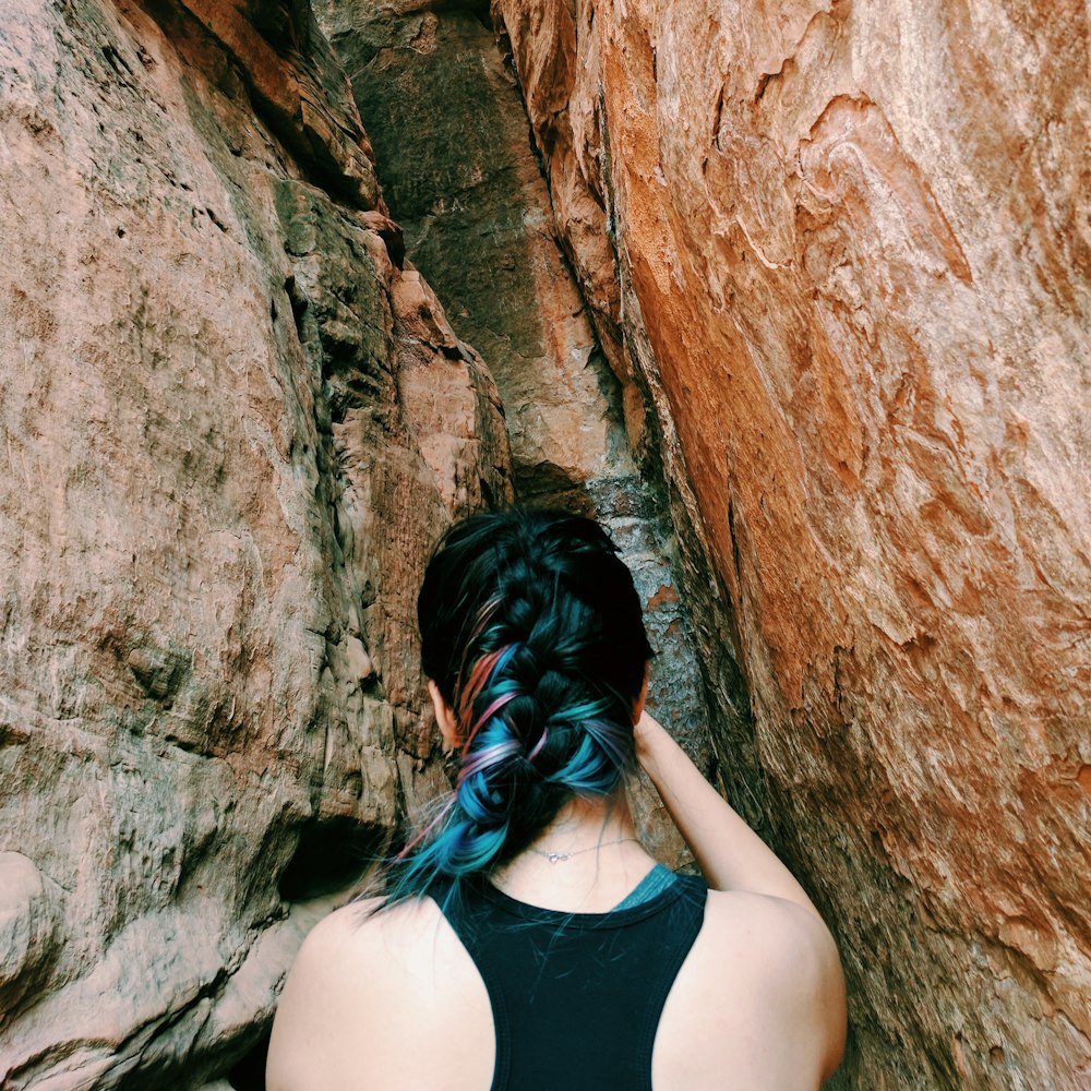 woman standing between brown rock formation