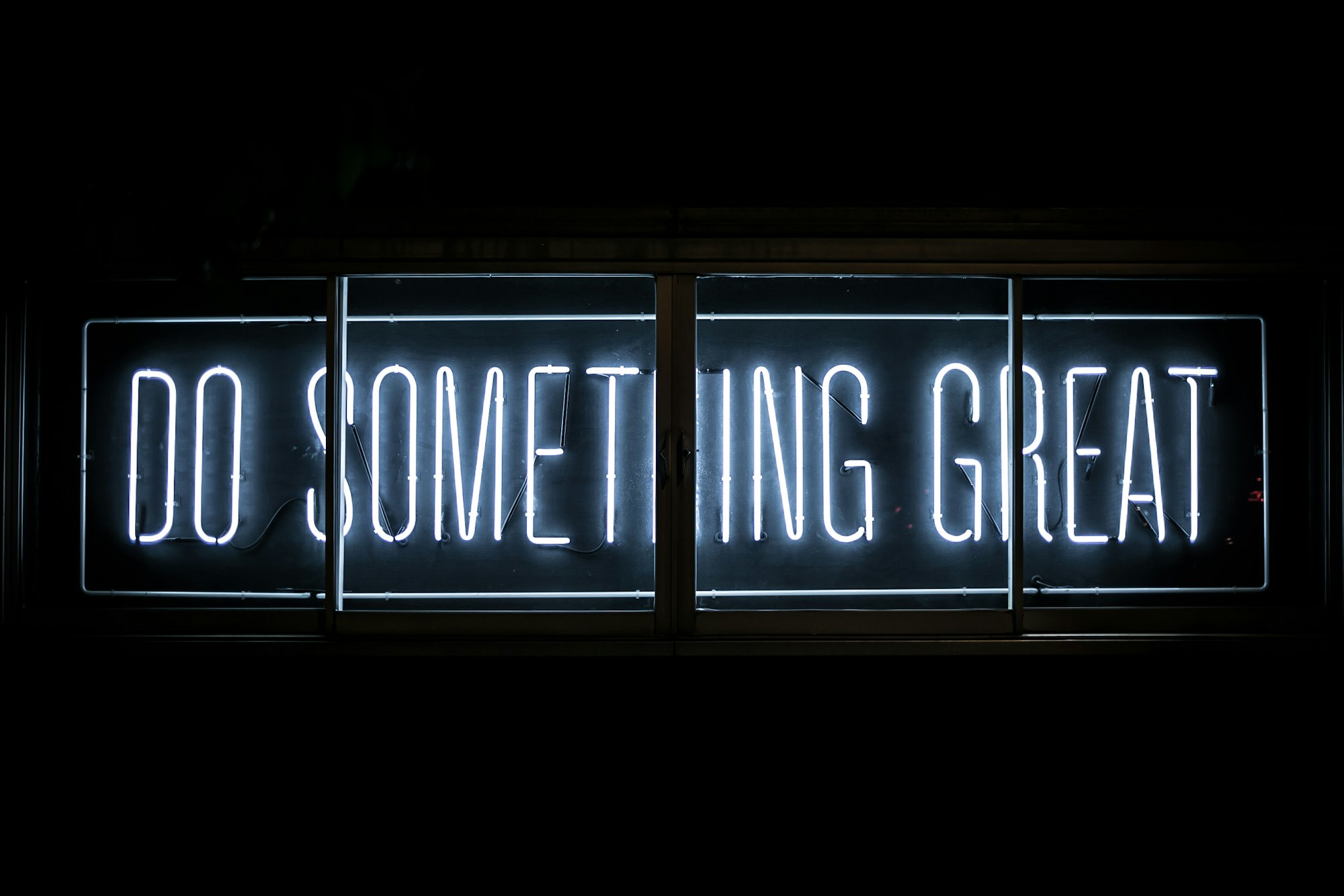 a neon sign reading "do something great"