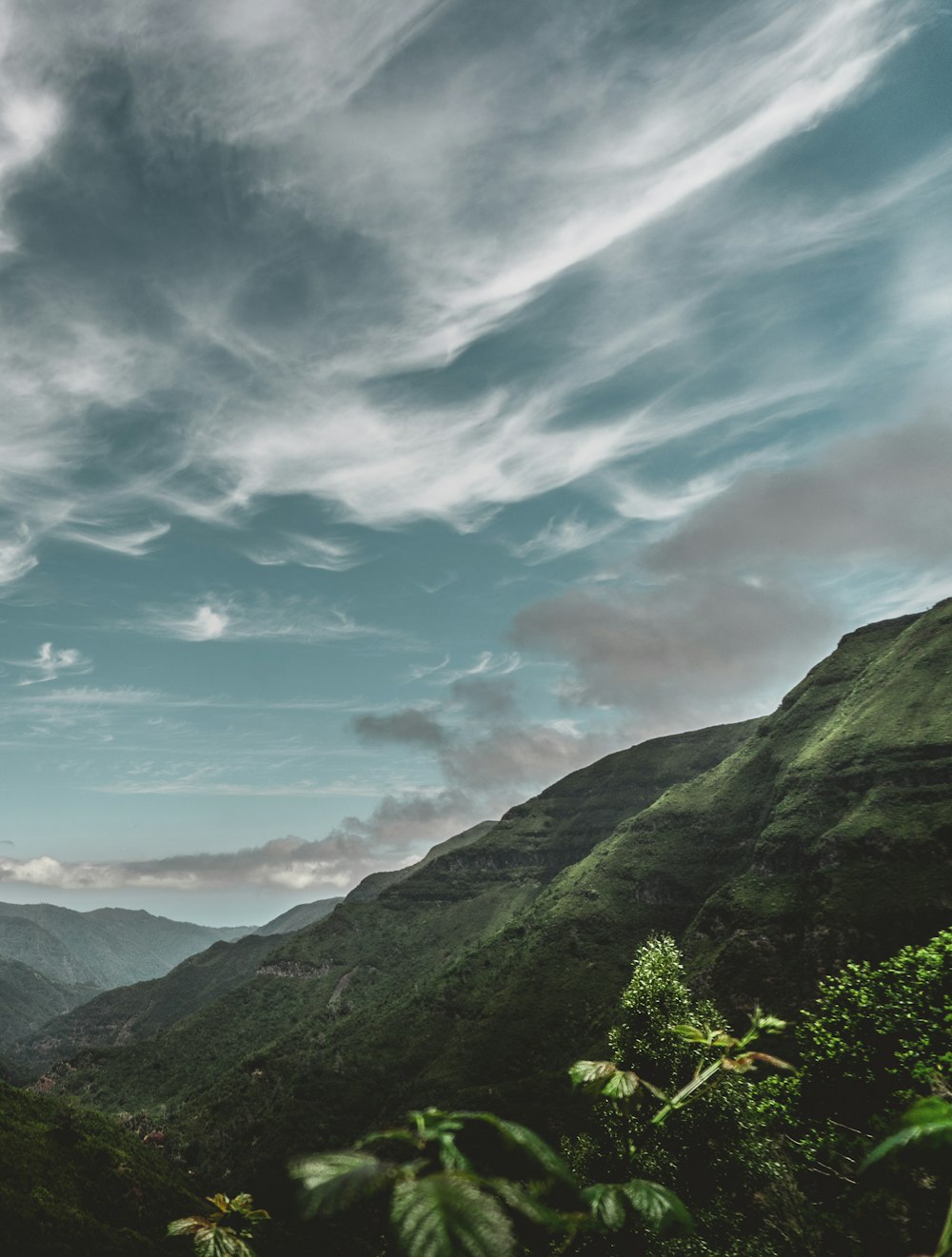 green mountains under blue cloudy skies