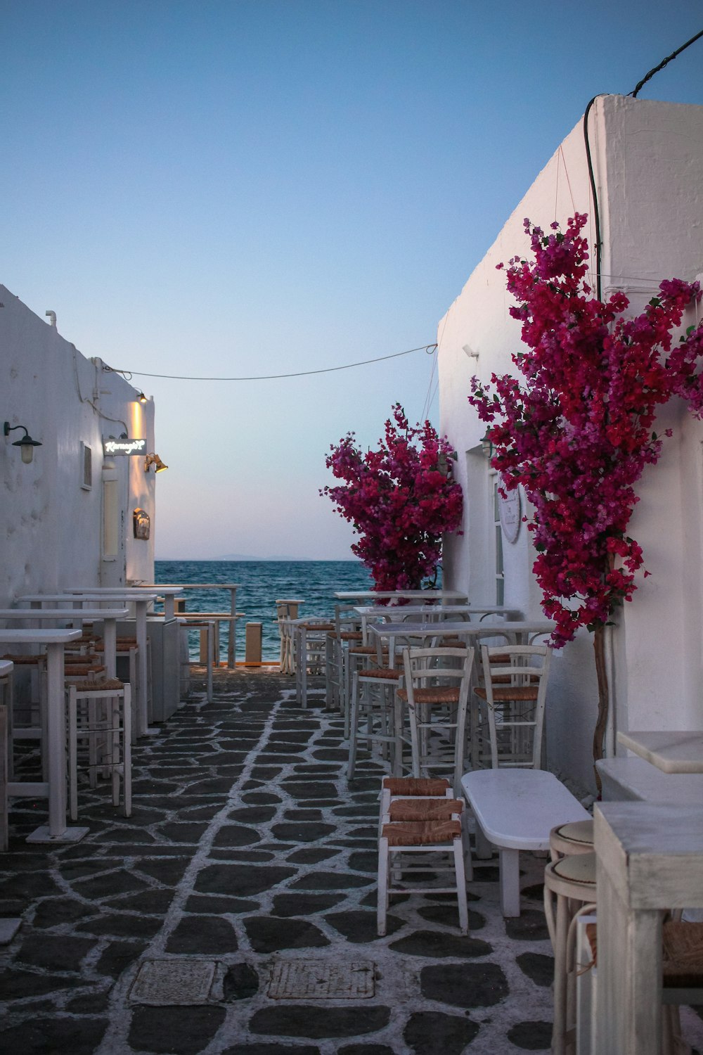 white wooden table and chairs near body of water