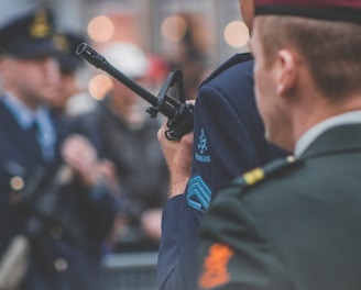 shallow depth of field photo of man holding rifle