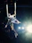 A smiling woman mid-pose on aerial silks in a bright, welcoming studio.