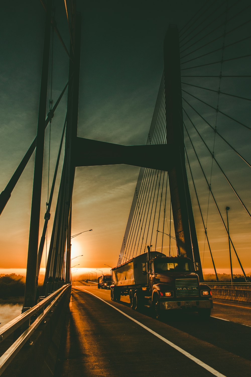 夜明けの橋の上の茶色のメーク貨物トラック