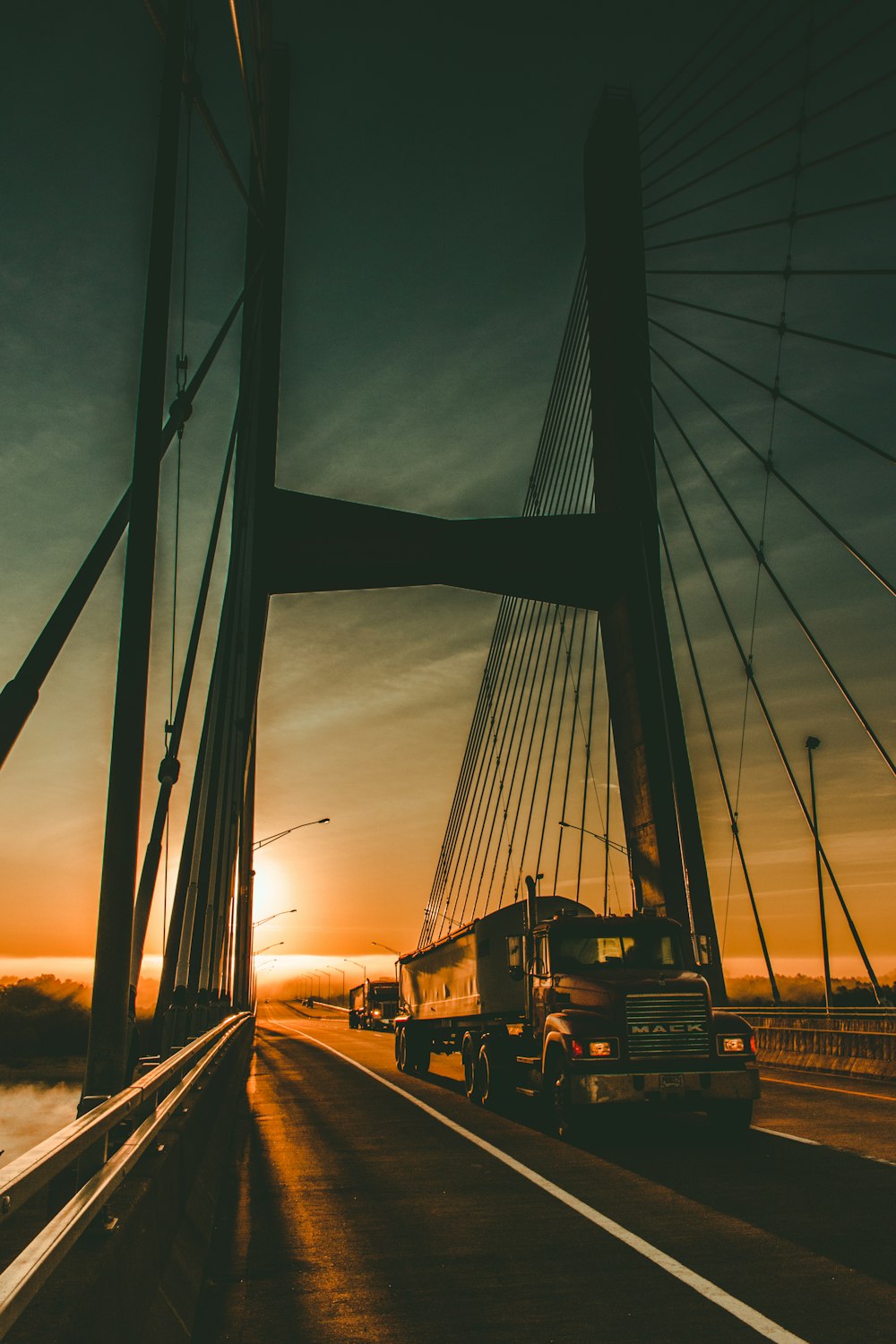 Camión de carga marrón Maek en el puente durante el amanecer