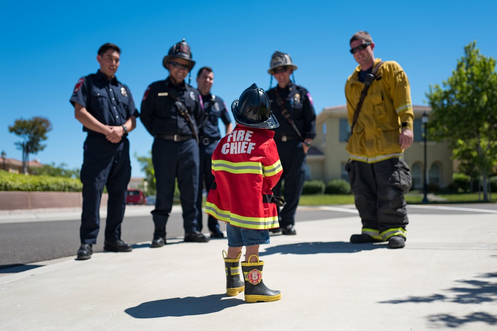 criança vestindo uniforme vermelho de bombeiro