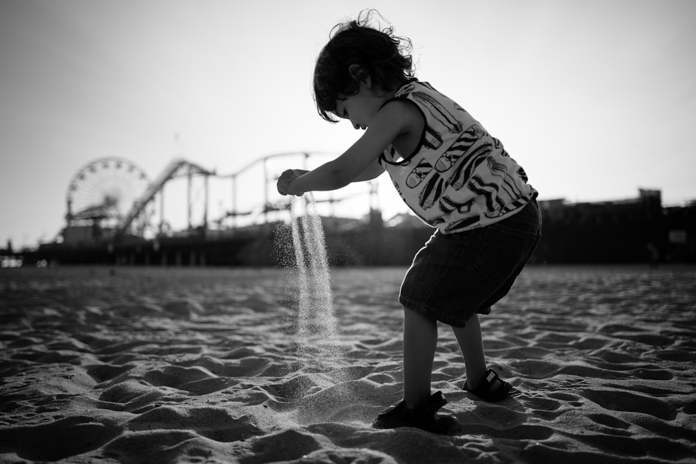 niño pequeño jugando a la arena de la playa