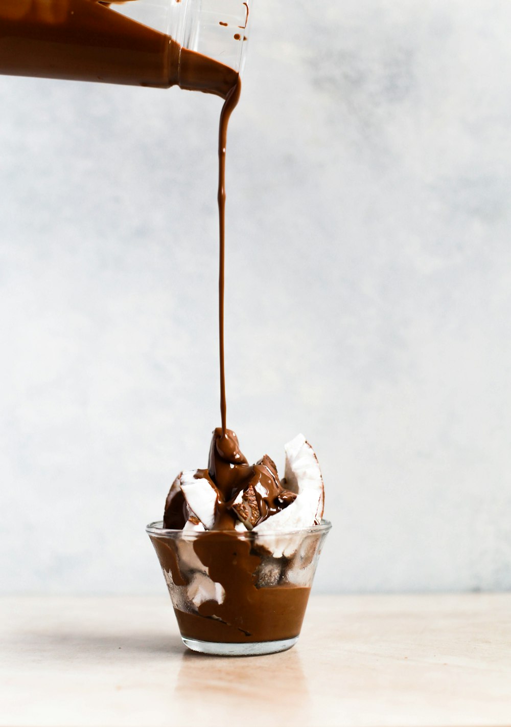 chocolate being poured onto glass with coconut skin