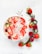 Close-up of a smoothie bowl topped with fresh fruits and edible flowers on a light beige background.