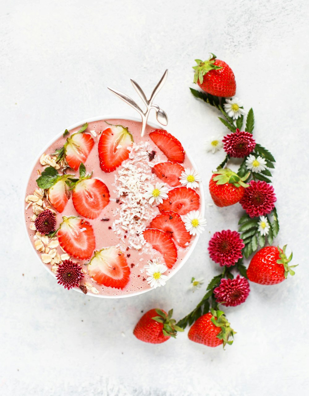 Trancher des fruits fraises sur un shake aux fruits avec des fleurs pétales