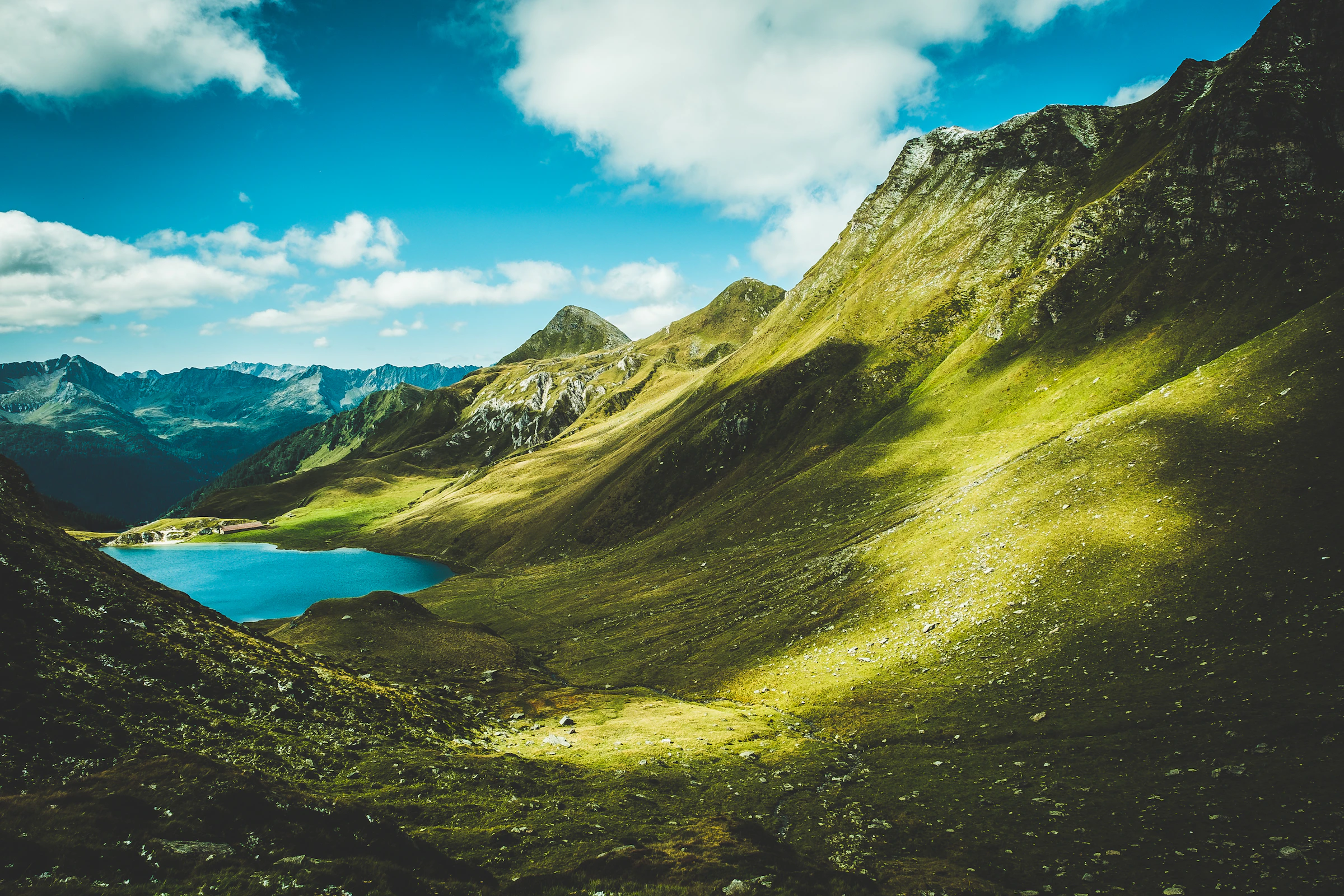 A turquoise lake beneath green peaks in the Swiss Alps
