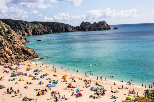 aerial shot of people on shore in Porthcurno Beach United Kingdom